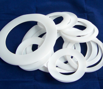Close-up of white PCTFE gaskets on a blue background.
